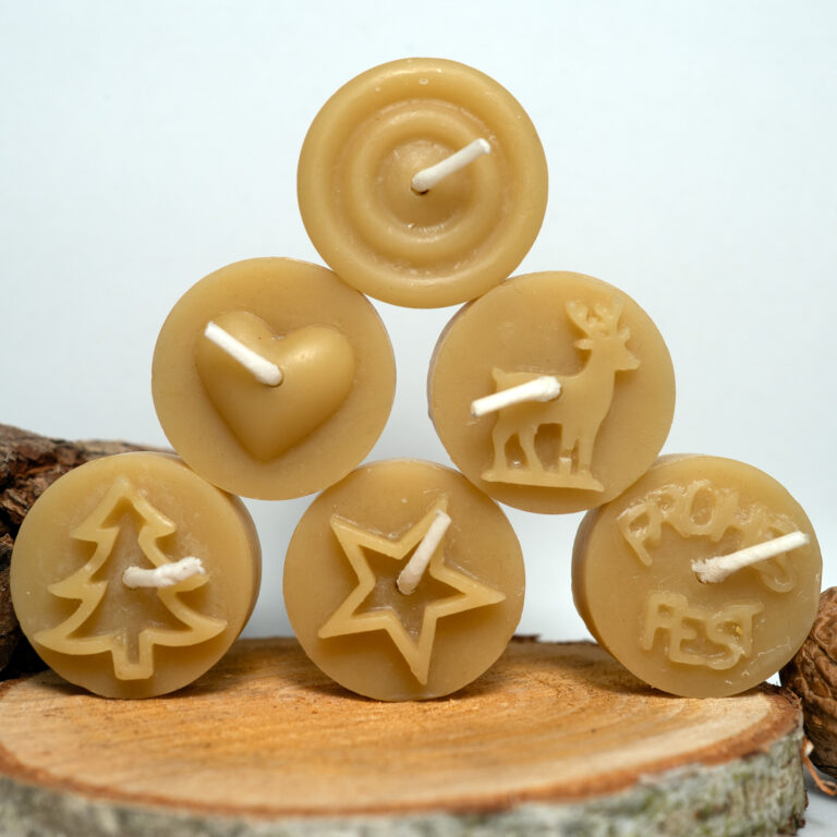 Verschiedene Bienenwachs-Teelichter mit dekorativen Motiven